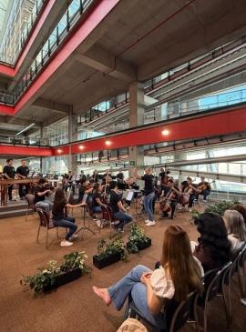 un grupo de personas sentada escuchando a un grupo de musica tocar