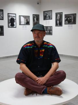 una persona sentada en una sala con cuadros alrededor 