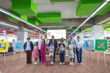 4 adultos y 7 niños parados cortando un liston